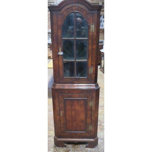 508 - A walnut one piece corner cupboard with an astragel glazed door over a cupboard door and painted int... 