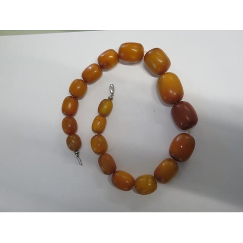 11 - A string of 18 amber type butterscotch beads - Length 49cm - largest bead approx 34mm x 22mm - total... 