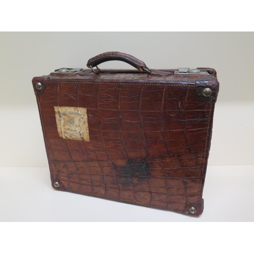 225 - A good early 20th century vintage crocodile suitcase with a fitted green leather interior with two s... 