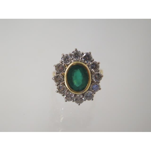 An 18ct yellow gold emerald and diamond cluster ring, head size approx 19mm x 17mm, emerald approx 8.5mm x 6mm x 4mm, approx weight 8.5 grams - in good condition