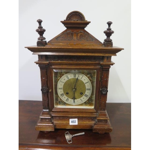 402 - An 8 day walnut bracket clock with quarter chime on two gongs, brass and silvered dial - running ord... 