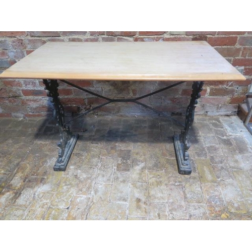 439 - A cast iron base table with a wooden top - Height 73cm x 106cm x 60cm