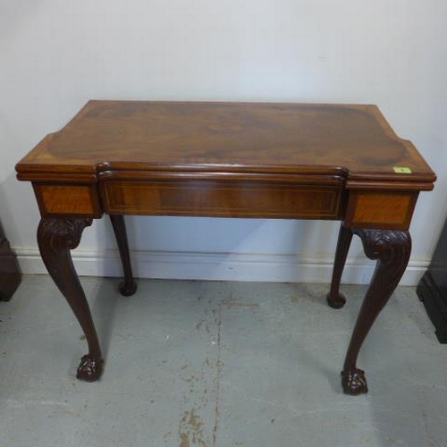 A restored George II mahogany fold over card table with a shaped top on carved cabriole legs and ball and claw feet - Height 73cm x 86cm x 42cm