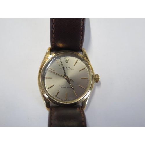 A gents 14ct yellow gold Rolex Oyster perpetual 1969 wristwatch with 34mm case - model 1002, case no. 2129837 with silver dial, on a brown leather strap with a box and outer box bought in 2012 with guarantee card and a receipt ,when bought it was origonally  sold with with a jubilee bracelet now has a leather strap- in good condition possible replacement glass  working order but gains time