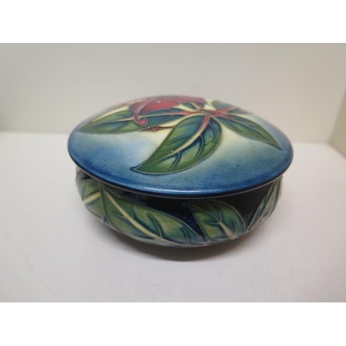 233 - A Moorcroft lidded pot 13cm diameter - in good condition