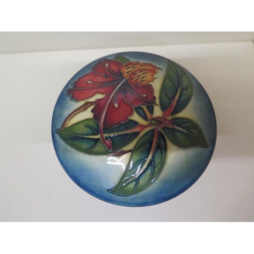 233 - A Moorcroft lidded pot 13cm diameter - in good condition