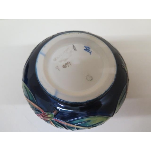 233 - A Moorcroft lidded pot 13cm diameter - in good condition