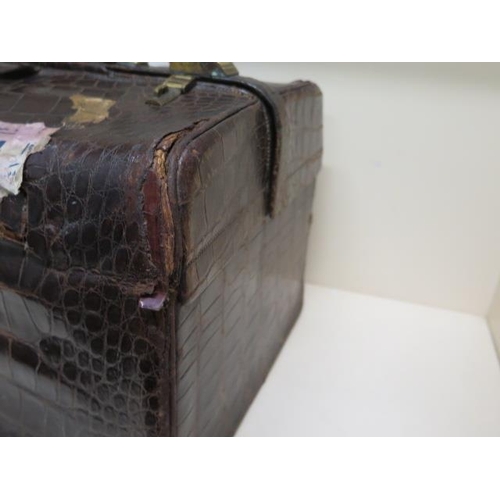 284 - An early 20th century crocodile travel case by Finnigan makers with a fitted interior including seve... 