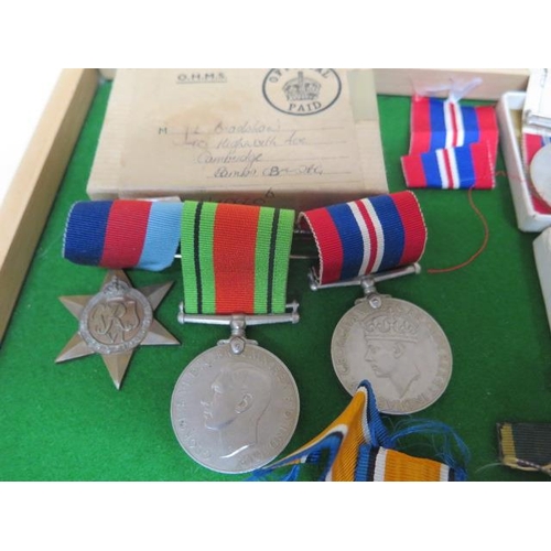 323 - A collection of WWI and WWII medals - a group of three unnamed WWII medals, a pair of WWII unnamed m... 