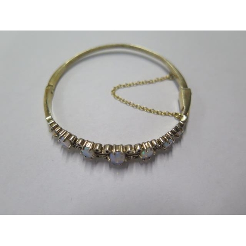 81 - A yellow gold hinged bracelet set with faux opals - 6cm x 5.5cm external - approx weight 11.8 grams ... 