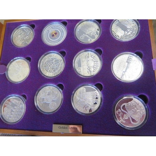 245 - A Royal Mint Queen Elizabeth II Golden Jubilee collection - 24 silver coins in a wood effect present... 