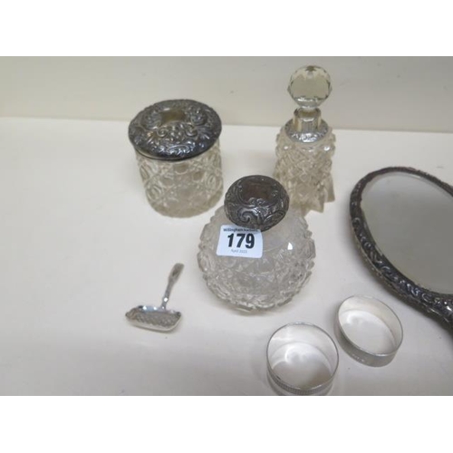 179 - A collection of four silver back brushes, a mirror, two bottles and a tidy with silver tops, two sil... 