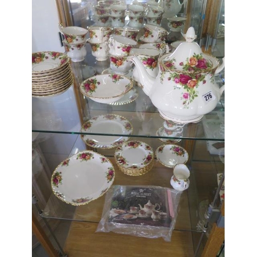 276 - A Royal Albert Country Rose tea set - tea pot, milk jug, sugar basin, a cake plate, nine cups, sauce... 