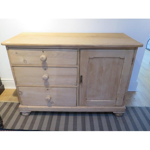 483 - A stripped pine Victorian dresser base with three drawers and a cupboard door  Height 85cm x 122cm x... 