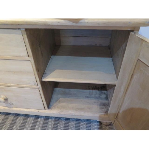 483 - A stripped pine Victorian dresser base with three drawers and a cupboard door  Height 85cm x 122cm x... 