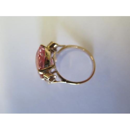 63 - A yellow metal dress ring - plain shank and bowed shoulders to large oval synthetic corundum (imitat... 