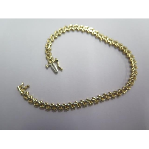 69 - A 14ct yellow gold diamond line set tennis bracelet set with 15 diamonds - total weight approx 7.3 g... 