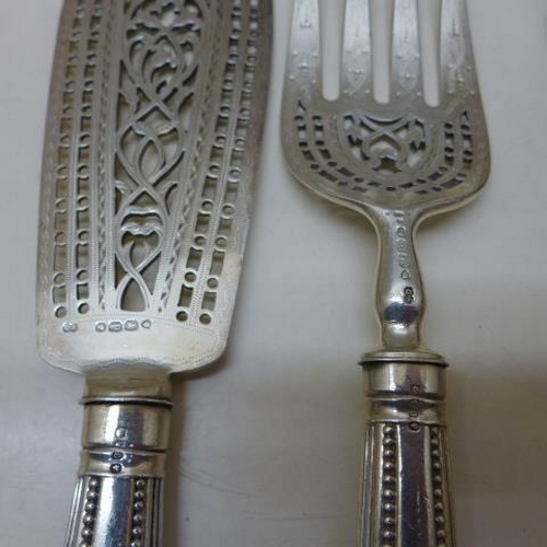 93 - A selection of seven silver and silver handle servers including asparagus tongs and a 30cm serving s... 