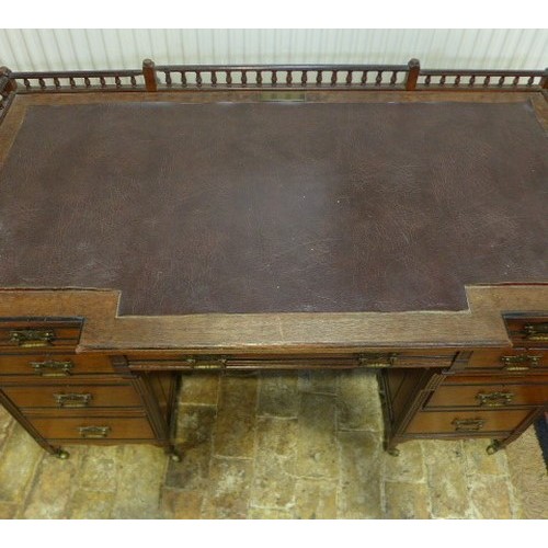 584 - A late 19th century arts and crafts mahogany breakfront desk with nine drawers - one drawer stamped ... 