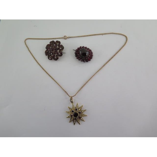 137 - A gilt metal garnet and pearl star pendant on a gilt chain (one pearl missing otherwise good) and tw... 