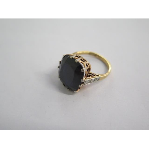 146A - An 18ct yellow gold ring with a large centre stone possibly a sapphire with diamonds to the sides, c... 