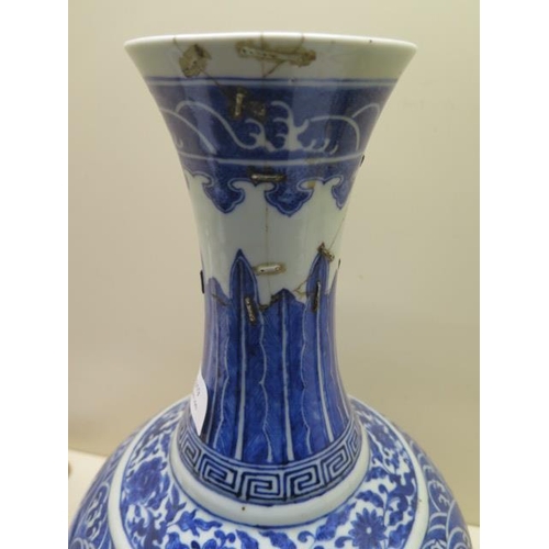 319 - An antique Chinese blue and white vase with old staple repairs to the neck - Height 40cm