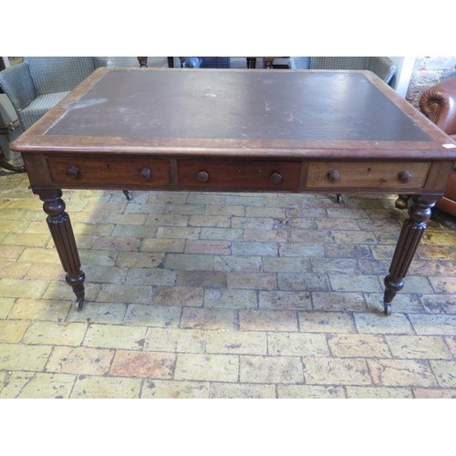 587 - A 19th century mahogany six drawer writing table on turned and reeded legs and brass caps and caster... 