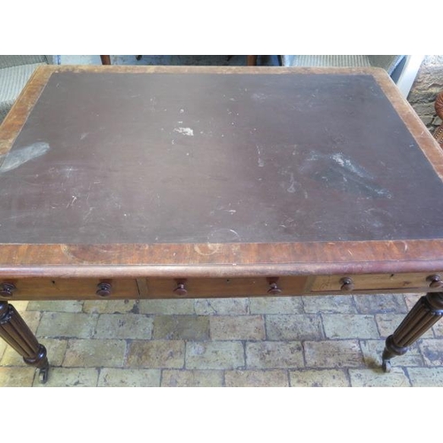 587 - A 19th century mahogany six drawer writing table on turned and reeded legs and brass caps and caster... 