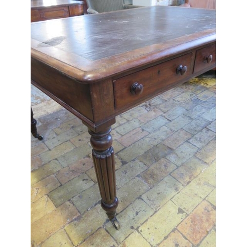 587 - A 19th century mahogany six drawer writing table on turned and reeded legs and brass caps and caster... 