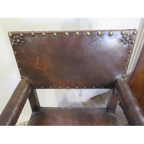 592 - A 17th/18th century oak armchair with a worn leather seat back and arms - sound condition and a nice... 