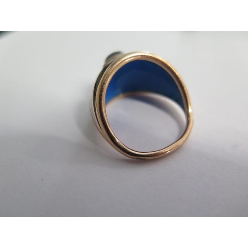 60 - A 9ct rose gold ring with a plain shank and graduating wide domed head with blue enamelled inside an... 