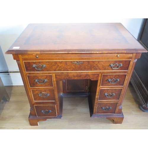 638 - A yew wood desk with a pull out writing slide, eight drawers - Width 86cm x Height 78cm x Depth 55cm