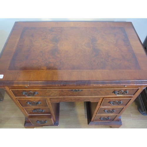 638 - A yew wood desk with a pull out writing slide, eight drawers - Width 86cm x Height 78cm x Depth 55cm