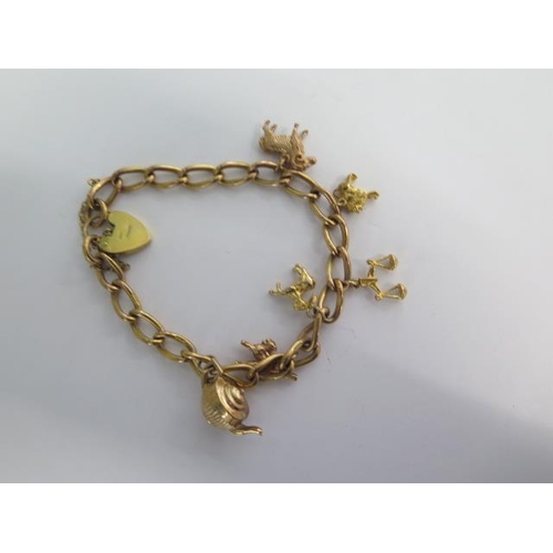 73 - A 9ct yellow gold charm bracelet with six charms - approx weight 29 grams