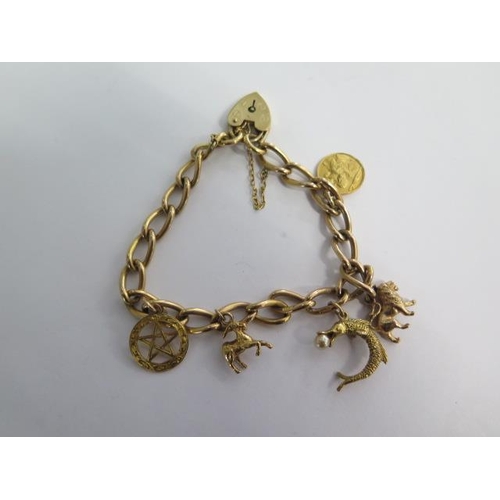 74 - A 9ct yellow gold charm bracelet with five charms - approx weight 28 grams