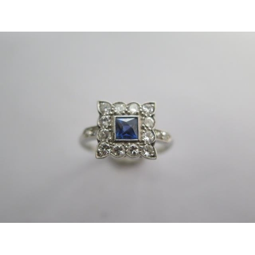 77 - A sapphire and diamond cluster ring consisting of a centrally mounted square blue sapphire surrounde... 