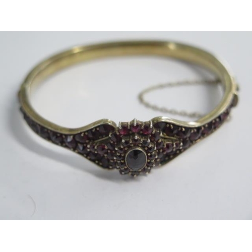 96 - A silver gilt hinged garnet bracelet - 6.5cm x 6.5cm external - head approx 1.8cm - in good conditio... 