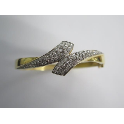 99 - An 18ct yellow gold diamond set crossover hinged bangle - 6.5cm x 5.5cm external - approx weight 25 ... 