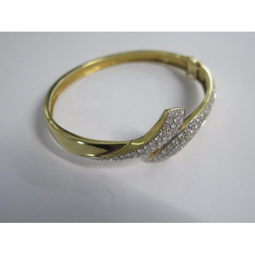 99 - An 18ct yellow gold diamond set crossover hinged bangle - 6.5cm x 5.5cm external - approx weight 25 ... 