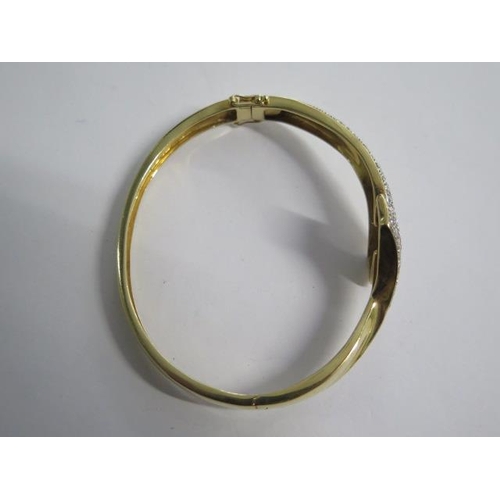 99 - An 18ct yellow gold diamond set crossover hinged bangle - 6.5cm x 5.5cm external - approx weight 25 ... 