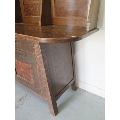 566 - A Liberty Arts & Crafts oak dresser with a glazed single door and two shelves over the base with a s... 