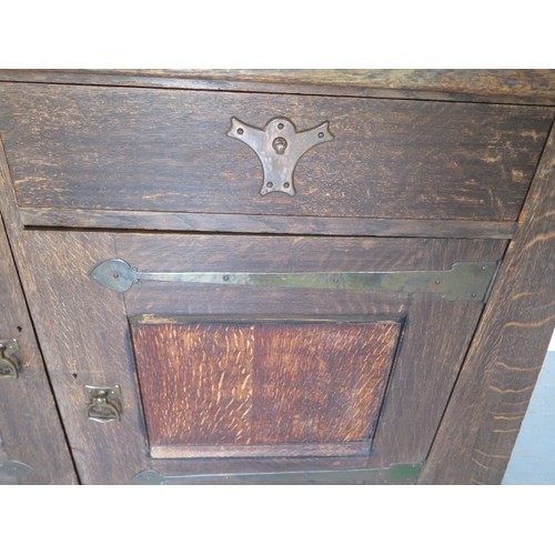 566 - A Liberty Arts & Crafts oak dresser with a glazed single door and two shelves over the base with a s... 