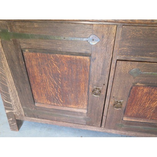 566 - A Liberty Arts & Crafts oak dresser with a glazed single door and two shelves over the base with a s... 