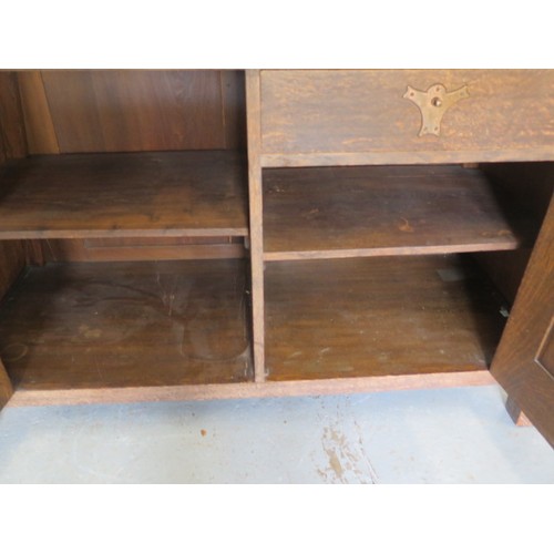 566 - A Liberty Arts & Crafts oak dresser with a glazed single door and two shelves over the base with a s... 