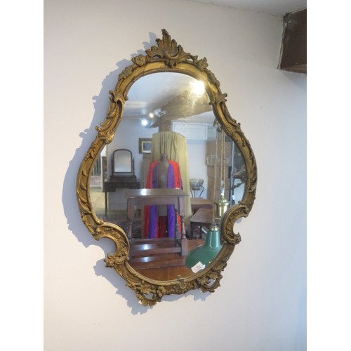 571 - An ornate gilt wall mirror - Height 80cm x 56cm