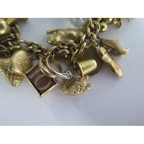 3 - A 9ct yellow gold charm bracelet with 35 assorted charms - approx total weight 76 grams