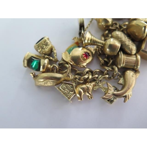 3 - A 9ct yellow gold charm bracelet with 35 assorted charms - approx total weight 76 grams