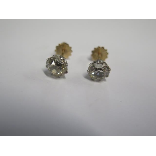 40 - A pair of diamond stud earrings in gold and white metal settings with screw backs - each diamond app... 
