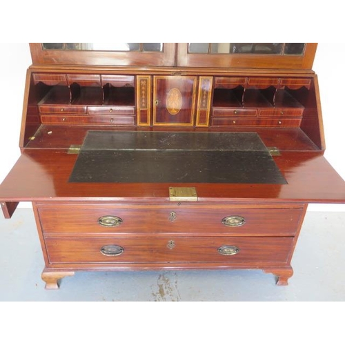 613 - An impressive Georgian mahogany bureau bookcase with a fretwork swan neck pediment, two astragal gla... 