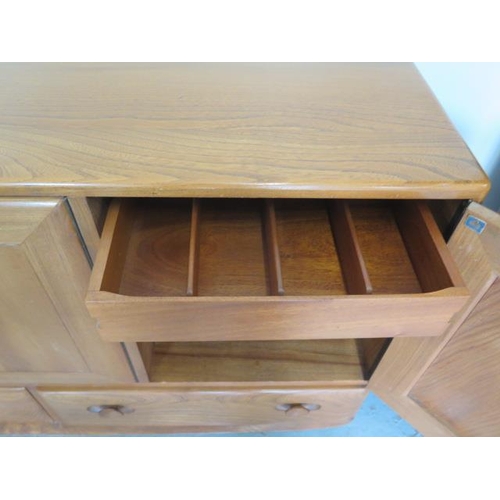 629 - A Ercol elm side cabinet with three doors and two doors with internal cutlery drawer - good conditio... 